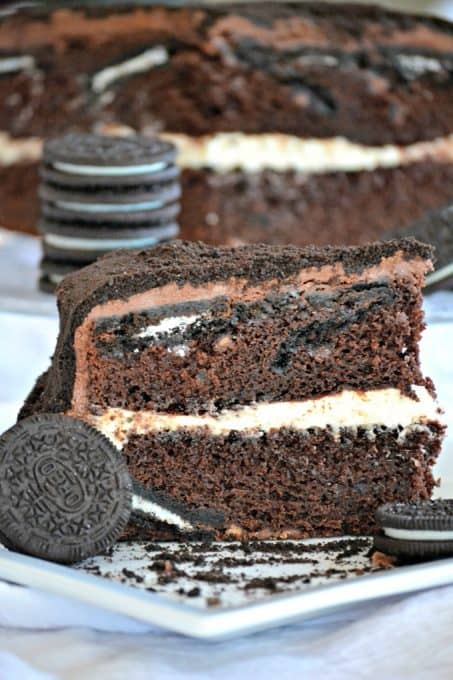 This Oreo Cake is a surprise-inside cake with chocolate layers, an Oreo filling, covered in chocolate buttercream and topped with Oreo cookie crumbs.