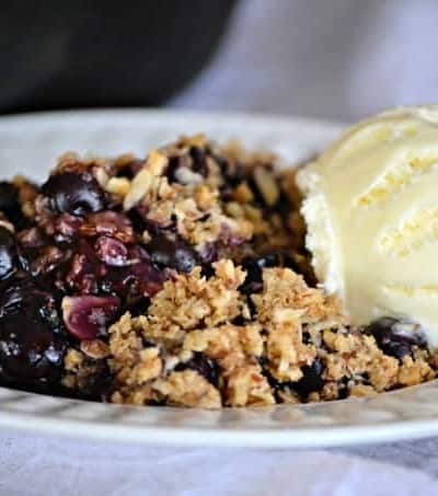 This Skillet Blueberry Crisp with fresh blueberries, an almond oatmeal topping and topped with a scoop of vanilla ice cream, make it the perfect dessert!