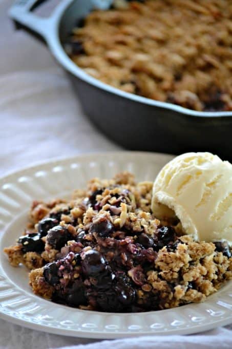 This Skillet Blueberry Crisp with fresh blueberries, an almond oatmeal topping and topped with a scoop of vanilla ice cream, make it the perfect dessert!