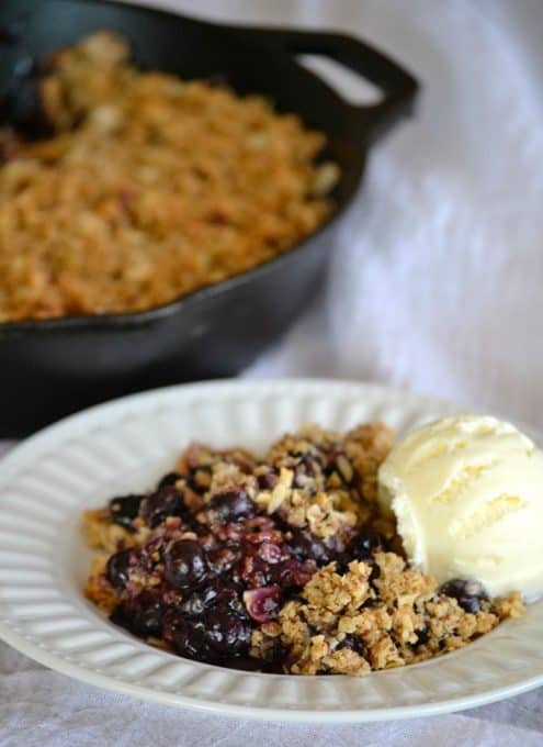 This Skillet Blueberry Crisp with fresh blueberries, an almond oatmeal topping and topped with a scoop of vanilla ice cream, make it the perfect dessert!