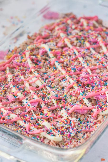 Drizzled white and pink chocolate on top of colorful rice krispie treats.