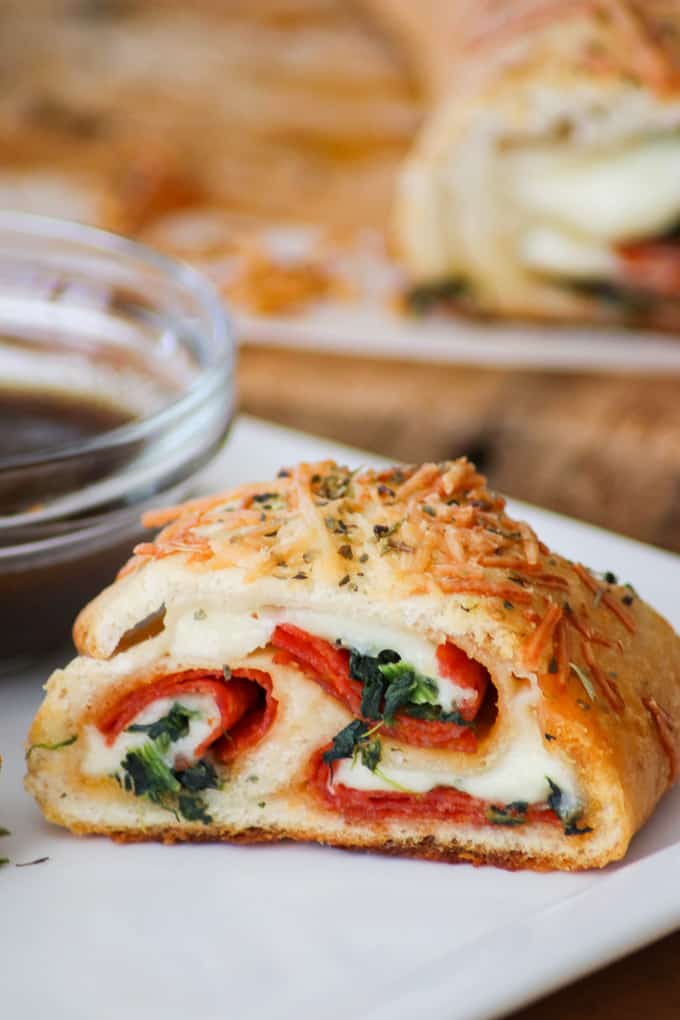 This Spinach Pepperoni Bread is pizza dough filled with spinach, pepperoni, and provolone. It makes a great weeknight dinner, is the perfect finger food for Game Day and is a recipe you'll be asked to bring again to that next potluck!