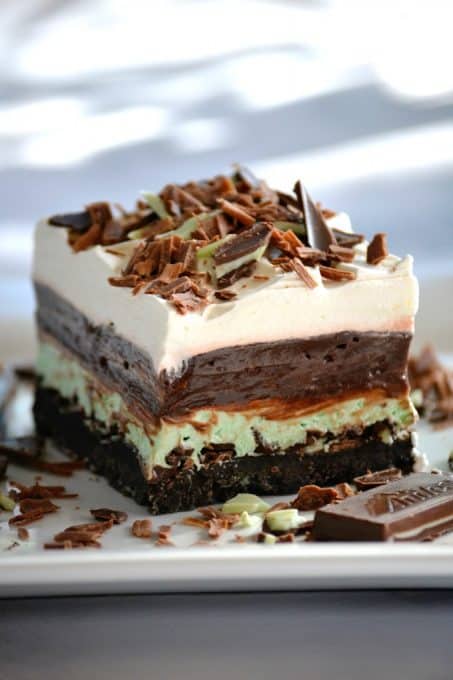 These Chocolate Mint Dream Bars are the perfect No-Bake dessert. The cookie crust, chopped Andes Mints, peppermint, pudding and whipped topping will have everyone swooning!