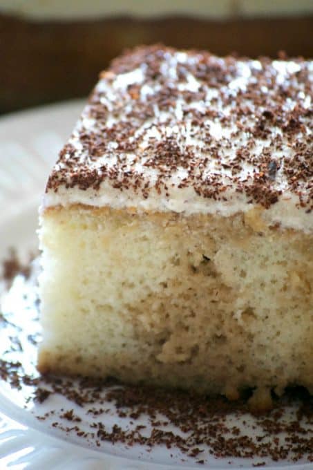 This Easy Tiramisu Poke Cake is a simple white cake drizzled with a sweetened coffee syrup, and topped with a whipped mascarpone vanilla frosting.