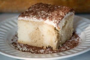 This Easy Tiramisu Poke Cake is a white cake mix drizzled with a sweetened coffee syrup, and topped with a whipped mascarpone vanilla frosting. It's a simple recipe to put together without the liqueur and uses Fair Trade ingredients.