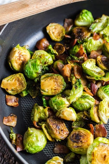 Cooking Brussels Sprouts in a pan with bacon and maple syrup.