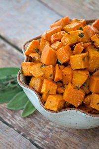 These Maple Roasted Sweet Potatoes are diced sweet potatoes tossed with olive oil, fresh sage and thyme, drizzled with pure maple syrup and roasted to perfection. They're the perfect side dish for your holiday table!