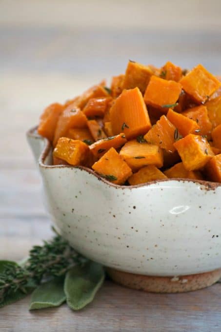 These Maple Roasted Sweet Potatoes are diced sweet potatoes tossed with olive oil, fresh sage and thyme, drizzled with pure maple syrup and roasted to perfection. They're the perfect side dish for your holiday table!