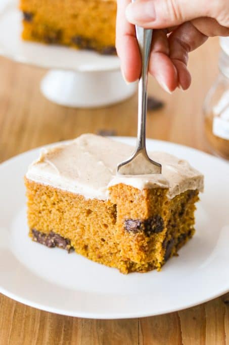 A bite take out of a pumpkin cake with chocolate chunks.