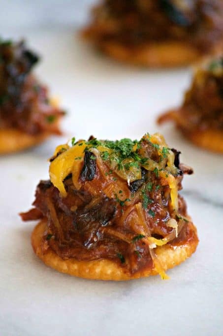 These Sweet and Spicy Coca-Cola Shredded Pork Bites are RITZ crackers topped with a bit of pork, caramelized onions, melted cheese and a dash of cilantro. Your Game Day taste buds will never be the same!