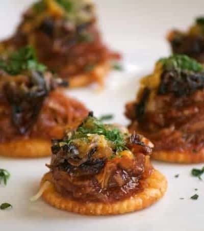 These Sweet and Spicy Coca-Cola Shredded Pork Bites are RITZ crackers topped with a bit of pork, caramelized onions, melted cheese and a dash of cilantro. Your Game Day taste buds will never be the same!