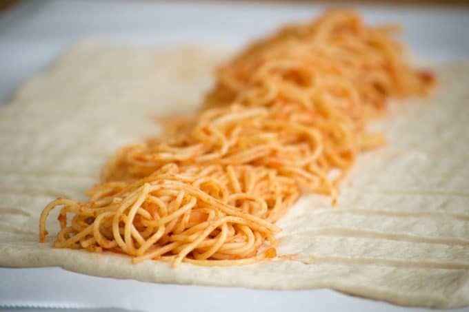 This Spaghetti and Meatball Braid is a new twist on good ol' comfort food - spaghetti and meatballs in pizza dough! It's a fun new way to feed the family.