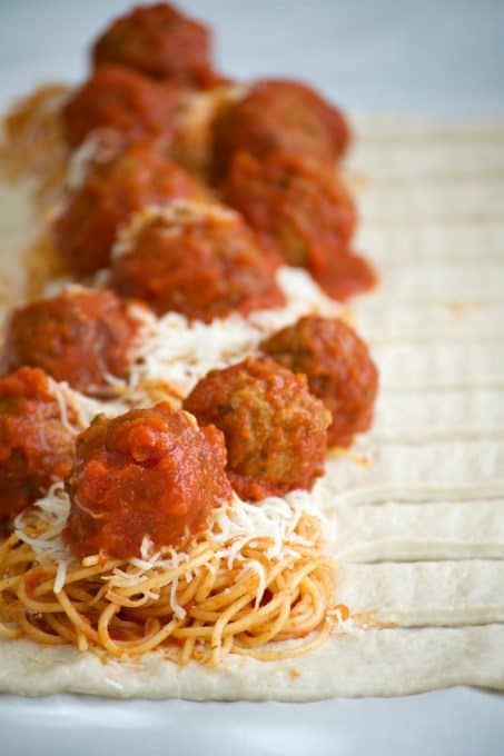 This Spaghetti and Meatball Braid is a new twist on good ol' comfort food - spaghetti and meatballs in pizza dough! It's a fun new way to feed the family.