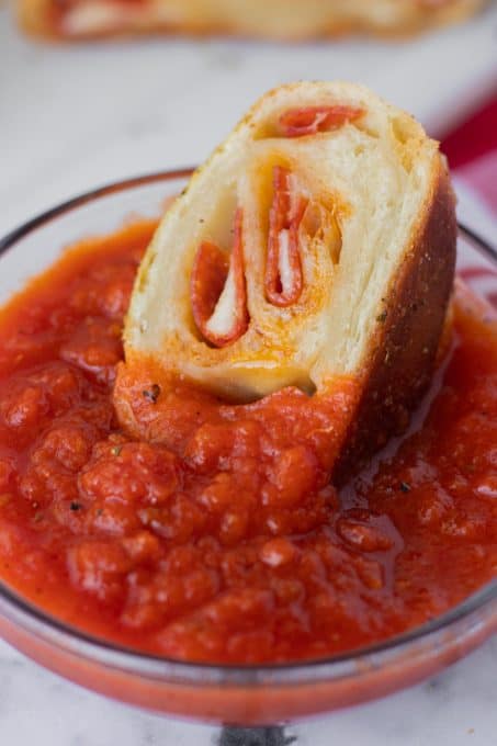A slice of bread filled with pepperoni and cheese.