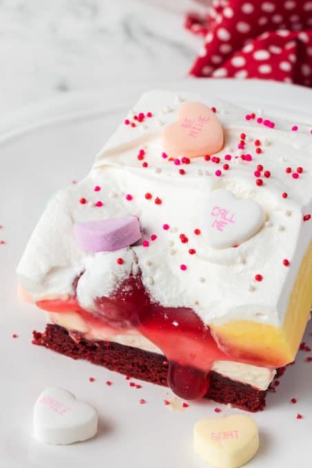 A red velvet dessert with cherries, cheesecake and vanilla pudding.