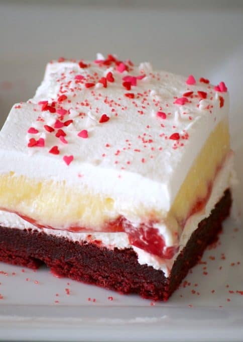 These Red Velvet Cherry Dream Bars with their red velvet cookie crust, sweet cheese layer, cherry pie filling, vanilla pudding and whipped topping make these bars the perfect holiday treat. Or better yet, enjoy them all year 'round.