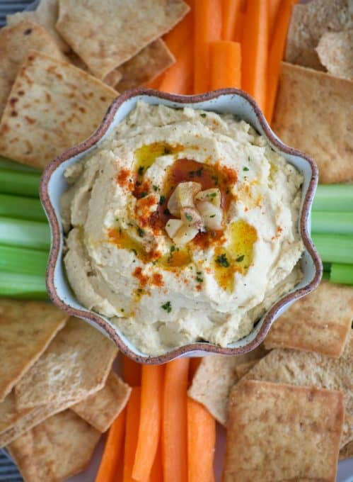 This Roasted Garlic Hummus is roasted cloves of garlic, tahini, lemon juice and spices. Served with pita chips or veggies, it's the perfect healthy treat. 