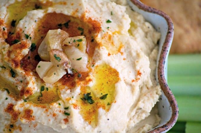 This Roasted Garlic Hummus is roasted cloves of garlic, tahini, lemon juice and spices. Served with pita chips or veggies, it's the perfect healthy treat.Â