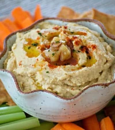 This Roasted Garlic Hummus is roasted cloves of garlic, tahini, lemon juice and spices. Served with pita chips or veggies, it's the perfect healthy treat. 