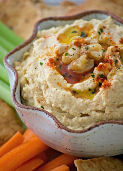 This Roasted Garlic Hummus is roasted cloves of garlic, tahini, lemon juice and spices. Served with pita chips or veggies, it's the perfect healthy treat.Â 