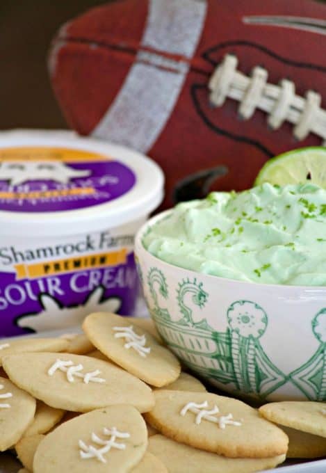 This Lime Cheesecake Dip made with cream cheese, confectioners' sugar, Shamrock Farms sour cream, lime juice and gelatin pairs perfectly with Football Sugar Cookies and some fresh fruit. It's the perfect Game Day treat and you'll be voted MVP!