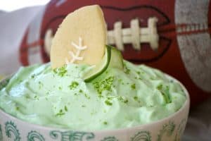 This Lime Cheesecake Dip made with cream cheese, confectioners' sugar, Shamrock Farms sour cream, lime juice and gelatin pairs perfectly with Football Sugar Cookies and some fresh fruit. It's the perfect Game Day treat and you'll be voted MVP!