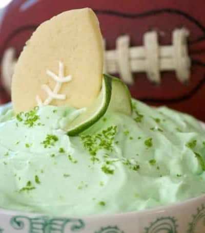 This Lime Cheesecake Dip made with cream cheese, confectioners' sugar, Shamrock Farms sour cream, lime juice and gelatin pairs perfectly with Football Sugar Cookies and some fresh fruit. It's the perfect Game Day treat and you'll be voted MVP!