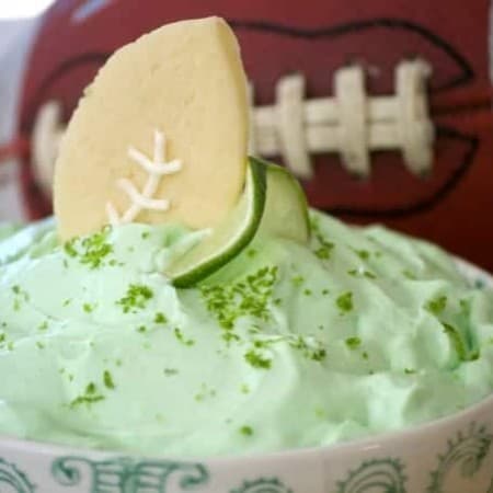 This Lime Cheesecake Dip made with cream cheese, confectioners' sugar, Shamrock Farms sour cream, lime juice and gelatin pairs perfectly with Football Sugar Cookies and some fresh fruit. It's the perfect Game Day treat and you'll be voted MVP!
