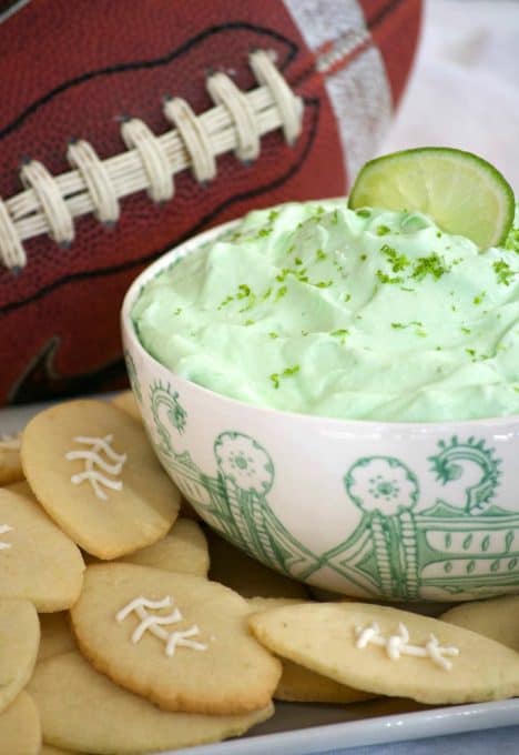 This Lime Cheesecake Dip made with cream cheese, confectioners' sugar, Shamrock Farms sour cream, lime juice and gelatin pairs perfectly with Football Sugar Cookies and some fresh fruit. It's the perfect Game Day treat and you'll be voted MVP!