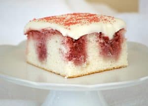 This Strawberry Poke Cake made from scratch with a white cake, strawberry sauce and cream cheese frosting is a perfect Valentine's Day or any day dessert.