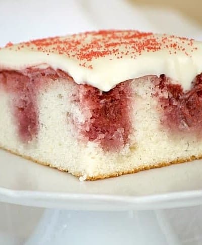 This Strawberry Poke Cake made from scratch with a white cake, strawberry sauce and cream cheese frosting is a perfect Valentine's Day or any day dessert.