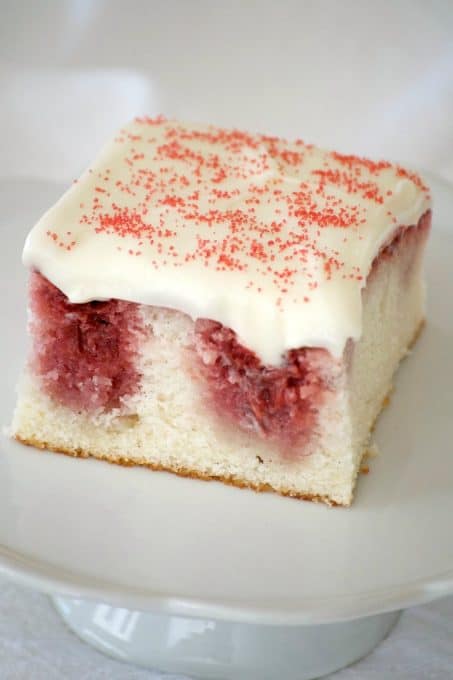 This Strawberry Poke Cake made from scratch with a white cake, strawberry sauce and cream cheese frosting is a perfect Valentine's Day or any day dessert.