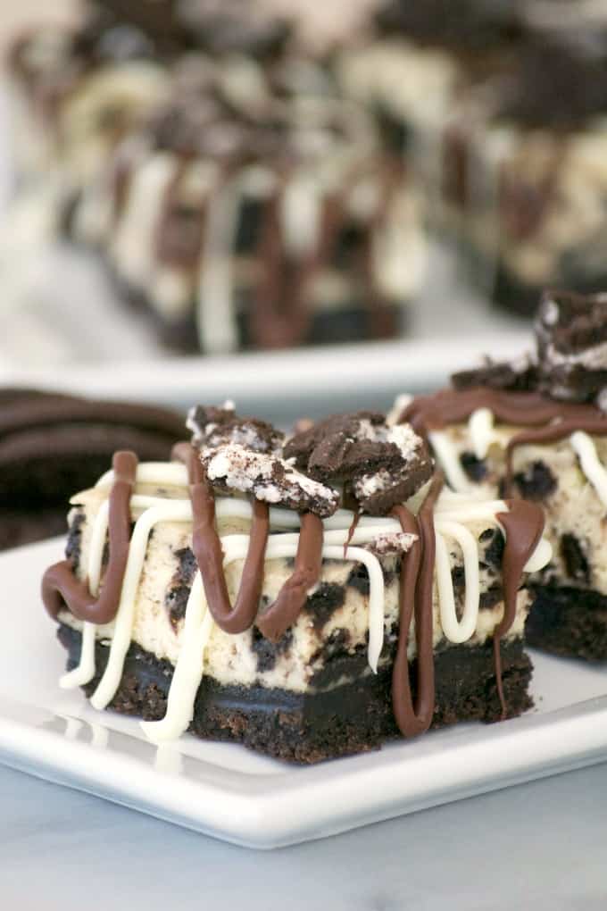 Everyone will love these Cookies and Cream Cheesecake Bars with their Oreo cookie crust, cookies and cream cheesecake layer and drizzled with chocolate.