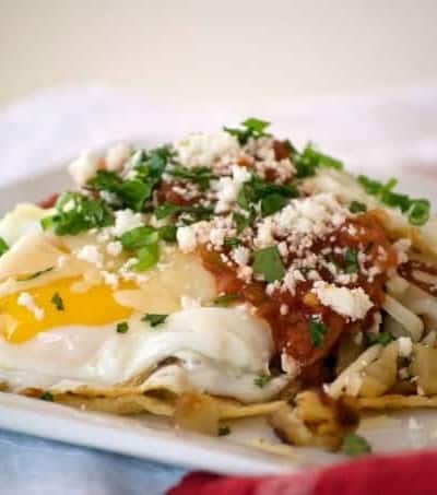 Loaded Huevos Rancheros are tortillas topped with refried beans, Potatoes O'Brien, salsa, eggs and cheese - a hearty breakfast that's full of great flavor!