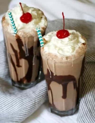 This Double Chocolate Malted Milkshake topped with whipped cream and a cherry is the perfect cold treat to satisfy a chocolate craving on a hot summer day.