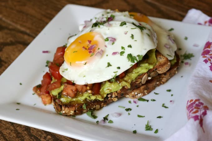 Bruschetta Fried Egg Avocado Toast with whole grain bread, smashed avocado, marinated tomato and a fried egg are sure to give you a great start to your day!