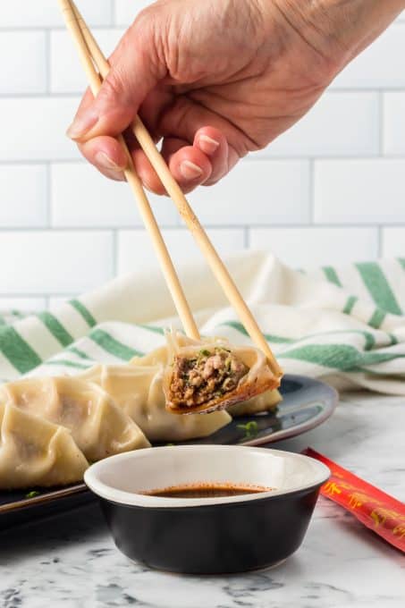 Potsticker dipped in sauce.