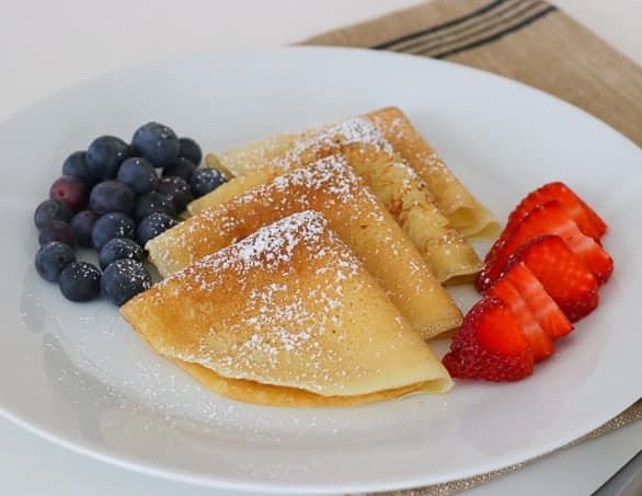 My family absolutely loves this Easy Crepe Recipe and yours will, too. Simply made with flour, eggs, milk and a little sugar, these thin French crepes or pancakes can be enjoyed a variety of ways. My favorite way to eat them is warmed with some pure maple syrup, but they're delicious with fillings, too!