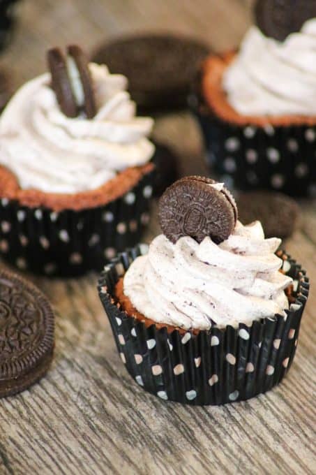 Mouth watering Chocolate Cookies and Cream Cheesecakes in wrappers topped with mini Oreos.