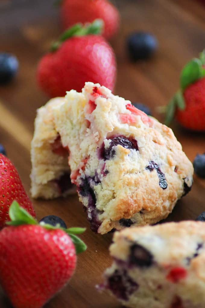 Mixed Berry Scones made with fresh strawberries and blueberries on a wooden tray with fresh berries.