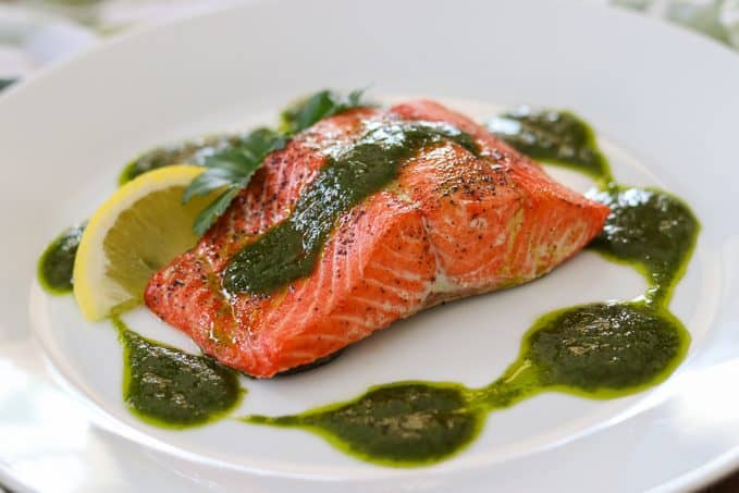 A salmon fillet topped with a chimichurri sauce. A salmon fillet topped with a chimichurri sauce.
