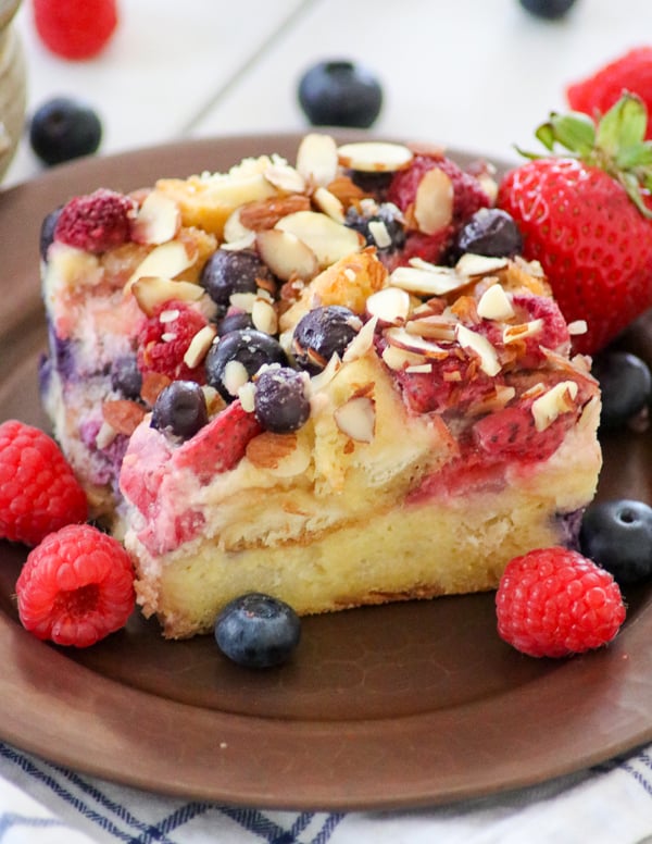 Almond Berry French Toast Casserole surrounded by fresh blueberries, raspberries and strawberries.