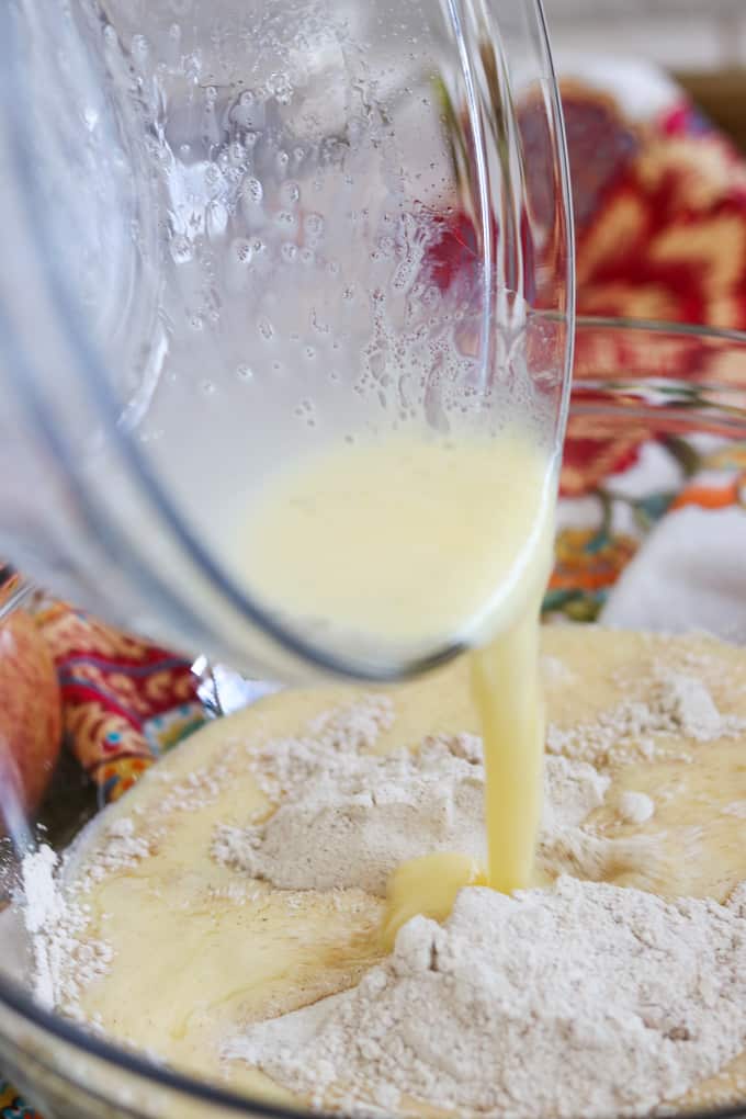 Pouring the wet ingredients into the dry ingredients to make Apple Streusel Muffins.