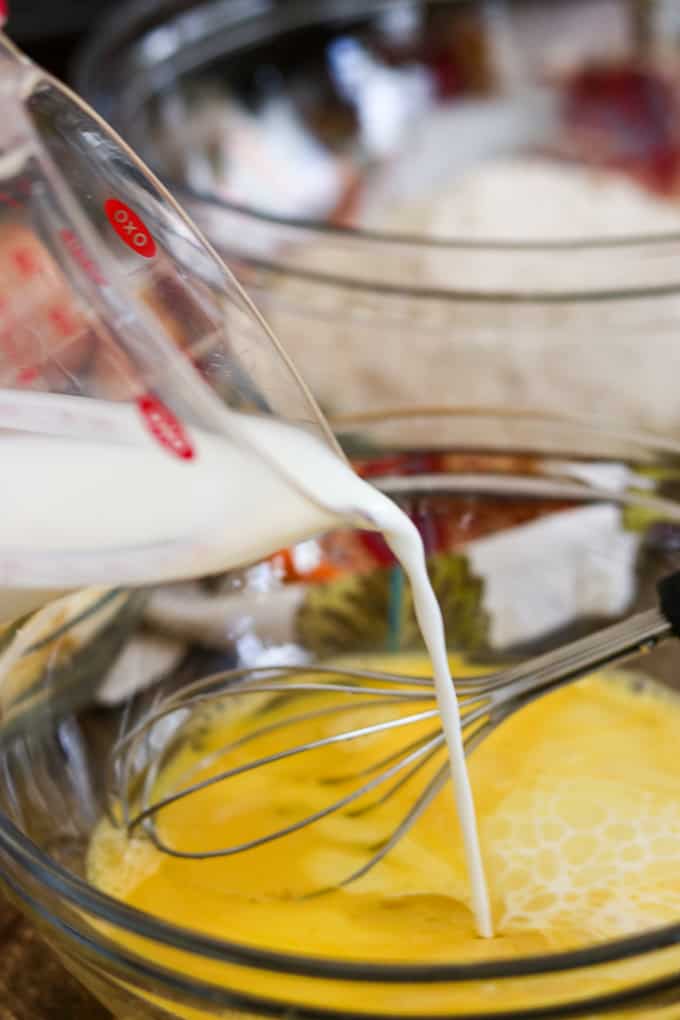 Pouring Shamrock Farms Organic Milk into an egg and oil mixture to make Apple Streusel Muffins.