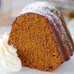 A slice of Chai Spiced Pumpkin Cake with dollops of fresh whipped cream.