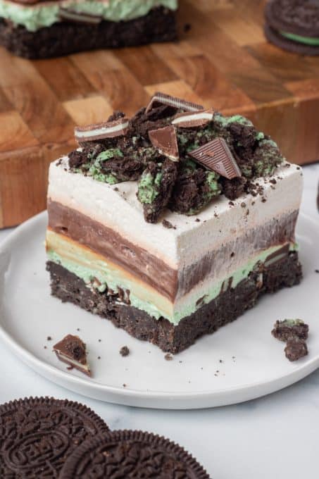 Cookie crust, mint cheesecake, chocolate pudding, Cool Whip and crushed mint cookies for a delicious no bake dessert.