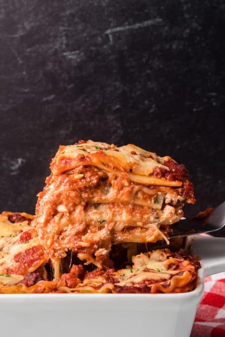 Pulling a slice of lasagna from the pan.