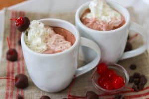 Two cups of Chocolate Covered Cherry Hot Chocolate with Reddi Wip.