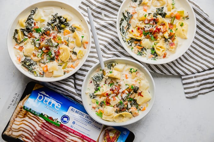 Bowls of One Pot Bacon and Tortellini Zuppa Toscana, and Pure Farmland Bacon.