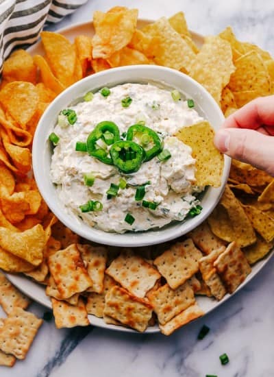 Jalapeño Ranch Dip in a bowl surrounded by chips and crackers.